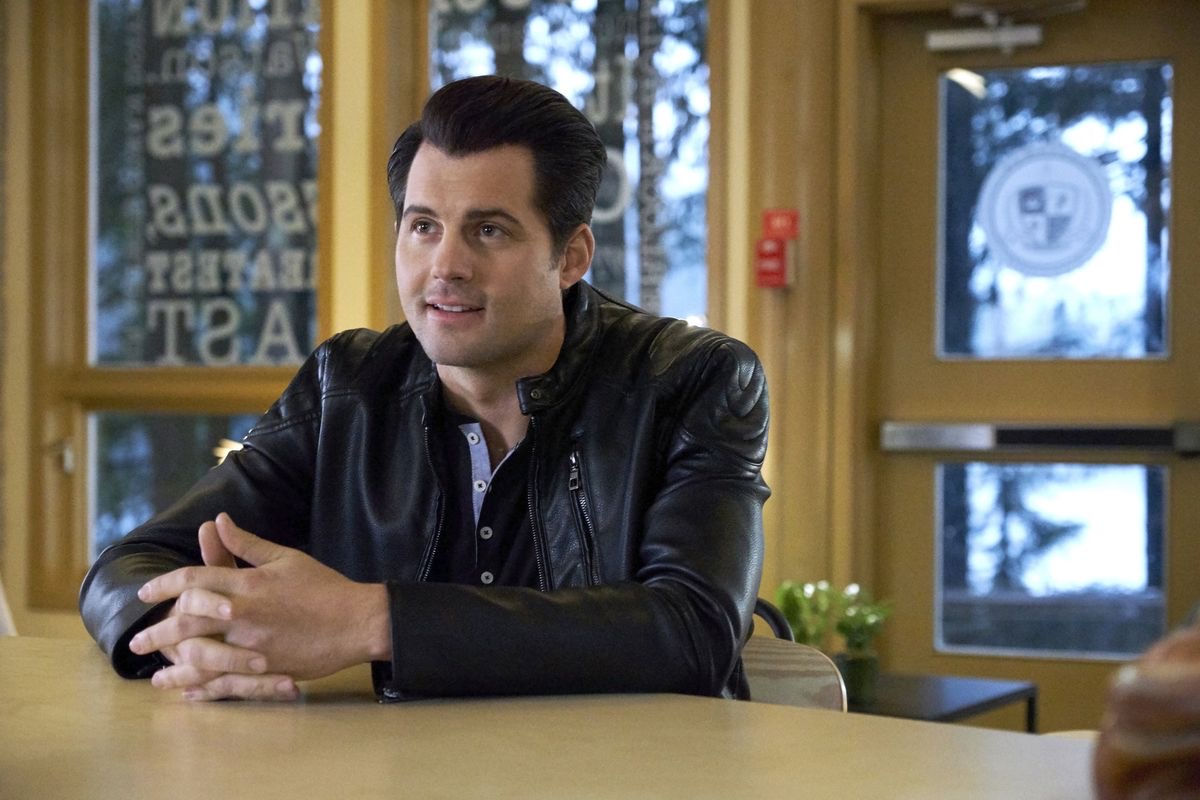 Kristoffer Polaha in a leather jacket during an interior scene
