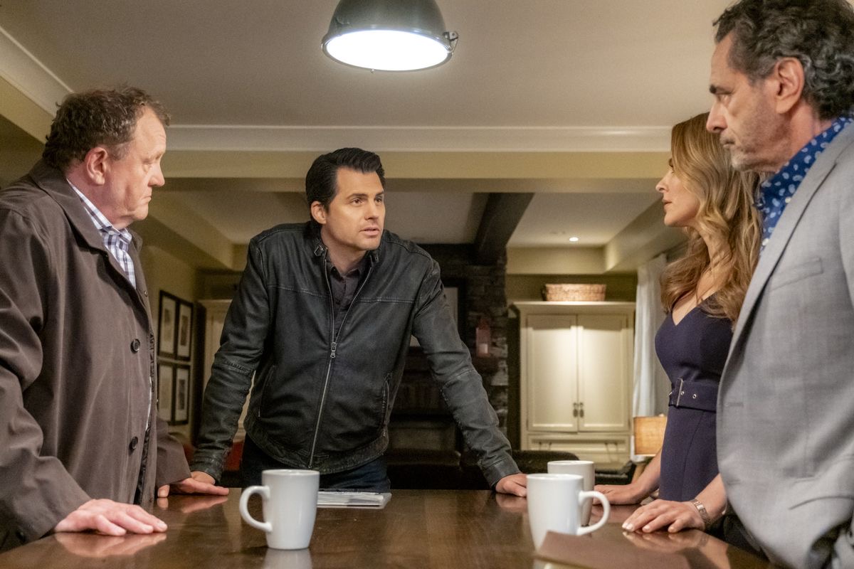 Ensemble scene with Kristoffer Polaha seated at a table